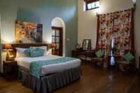 Green-walled bedroom with floral curtains