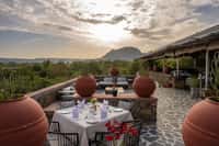 Rooftop dining terrace laid for dinner facing the hills