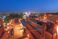 Rooftop restaurant lit at night above the city