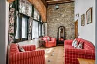 Sitting room with red sofas and stone wall