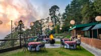 Lawn dining tables with lanterns at dusk