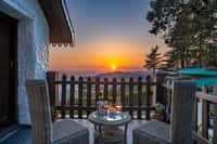 Balcony chairs facing sunset over the ridge