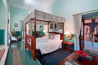 Canopy bed and rugs in green-floored room