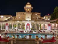 Lit palace and swimming pool at night