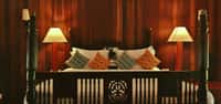 Four poster bed against rosewood panelling