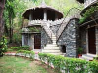 Round stone cottage with thatched roof and external stair