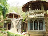 Two stone pavilions with conical thatch and lattice windows