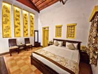 A room at Tathastu Pench with a high tiled roof and a four-poster bed