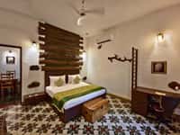 A villa room at Tathastu Pench, patterned floor and timber headboard