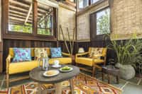 The yellow armchairs of the lounge at Pench Tree Lodge