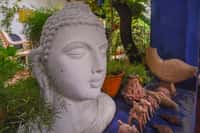 Stone Buddha head and terracotta figures in the garden