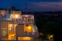 Coral Court exterior at dusk, lit house against evening sky