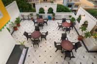 Crenellated second-floor terrace with round tables and planters