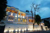 The lit facade of Dev Mahal at dusk, jharokha balconies and jali screens, Bani Park, Jaipur