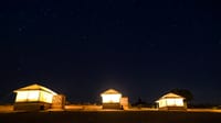 Three tents glowing under a starry desert sky, Dhora Desert Resort & Spa, Shekhala
