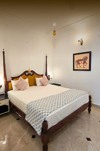 King bedroom with marigold-upholstered headboard and horse painting, Diwan House, Agra