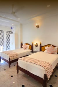 Twin-bedded room with block-printed quilts and blue-and-white blinds, Diwan House, Agra