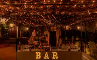 Open-air bar under a vine-covered pergola strung with fairy lights, Fort Dhariyawad, Dhariyawad