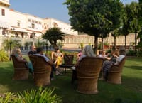 Guests seated in cane chairs on the lawn in front of the fort, Fort Dhariyawad, Dhariyawad
