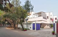 White heritage mansion with blue gates on a tree-lined residential street, Haveli Hauz Khas, New Delhi