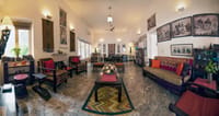 Living room with carved wood furniture, durries and the hosts' photography on the walls, Haveli Hauz Khas, New Delhi
