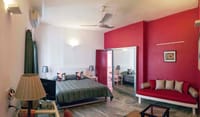 Kama room with deep red wall, day bed and mirrored wardrobe, Haveli Hauz Khas, New Delhi