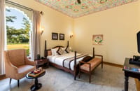 Super Deluxe Room with arched windows and king-size bed, Kesar Bagh Palace, Chittorgarh