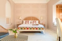 Bedroom with white Jaipur-style wall motifs and a kilim-upholstered bench, Niravi, Jaipur