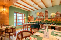 Restaurant interior with hand-painted Jaipur mural and cane-backed chairs, Niravi, Jaipur