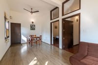 Family villa living area with dining table and twin bedroom doorways, Soulacia Hotel & Resort, Kanha