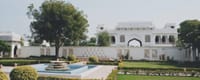 Castle gardens with fountain, parterre lawns and gatehouse beyond, Talabgaon Castle, Talabgaon