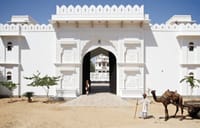 Carved white entrance gate with doorman and camel cart outside the walls, Talabgaon Castle, Talabgaon