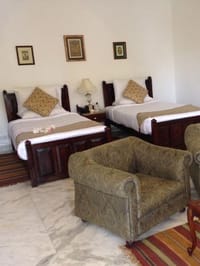 Deluxe Room with twin beds and upholstered armchair, Talabgaon Castle, Talabgaon
