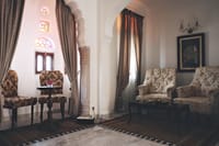 Suite sitting area with armchairs, marble floor and stained-glass niches, Talabgaon Castle, Talabgaon