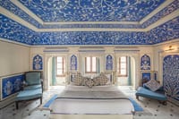 A guest room painted in blue and white frescoes