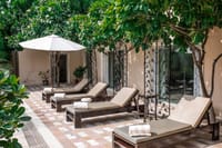 Loungers beside the marble and sandstone pool