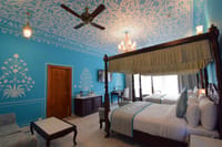 Suite interior with hand-stencilled blue walls and four-poster bed