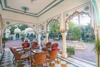 Cane seating in a painted verandah overlooking the courtyard