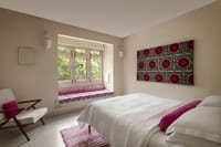 A room with block-printed textile art above the bed