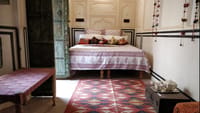 A bedroom with block-printed cover and a Jaipur rug