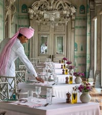 Tables being laid in the mirrored dining room