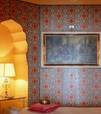 A bedroom corner, wall to ceiling in block-printed pattern