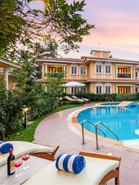Pool and ochre villas at sunset with loungers