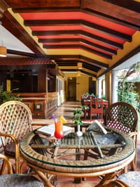 Veranda lounge with cane furniture and painted ceiling