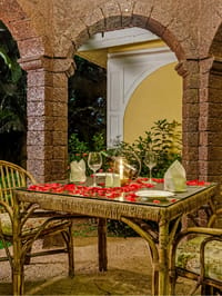 Candle-lit dinner table under stone arches