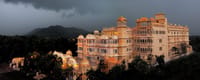 Chunda Palace exterior lit at dusk against the Aravali hills
