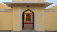 Arched entrance gate of the yellow castle facade, lit in the evening