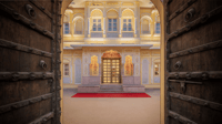 Rustic wooden door opening onto the red-carpeted courtyard