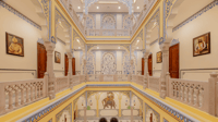 Corridor with miniature-style wall paintings and staircase
