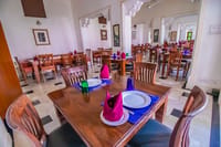 Dining hall with carved wooden tables laid for a meal